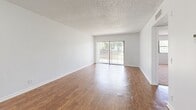 Located in Tamarac, Florida, this one-bedroom, one-bathroom residence offers a compact and efficiently designed layout across a single floor. The living room is a bright, open space highlighted by warm wood-look laminate flooring, crisp white walls, and a textured ceiling. A sliding glass door fitted with vertical blinds floods the room with natural light and provides views of the greenery outside. The same flooring flows through the entryway, creating a cohesive feel throughout the main living areas. The kitchen features rich wood cabinetry, granite-style countertops, a built-in dishwasher, and a deep sink — offering both style and practicality in a well-organized space. The bedroom is a comfortable retreat with soft wall-to-wall carpeting, a large window with outdoor views, and a wide double bi-fold closet that provides ample storage. The bathroom is clean and straightforward, appointed with a full tub-shower combo, white tile surround, and a vanity with granite-style countertops that echo the kitchen's design. Textured ceilings throughout the home add a classic Florida residential character, while the overall neutral palette creates a bright and welcoming ambiance throughout.
