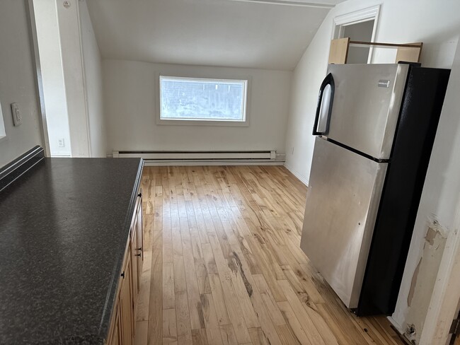 View from the kitchen into the dining area. Living room to the left. Bedroom to the right. - 25 Monroe St