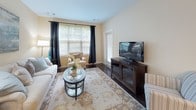 Located at 8 Digital in Nashua, NH, this single-floor residence offers a thoughtfully designed layout with a seamless flow between living, dining, and kitchen spaces. The kitchen is a standout feature, equipped with rich dark wood cabinetry, granite-style countertops, a full suite of black appliances including a refrigerator, range, dishwasher, and microwave, and a large peninsula with pendant lighting — ideal for both meal prep and casual dining. Dark hardwood-style flooring grounds the kitchen and main living areas with warmth and elegance.

The living room is bright and welcoming, featuring large windows dressed with horizontal blinds and floor-length draping curtains that invite natural light while maintaining privacy. Neutral wall tones create a calm, versatile backdrop throughout the space.

The unit includes two well-proportioned bedrooms, each featuring plush carpet, natural window views, and ample room for storage. The primary bathroom is finished with a dark wood vanity, granite countertop, tile flooring, and a full tub/shower combination. A second full bathroom mirrors the clean, functional design with its own tub/shower and tiled flooring.

Overall, the residence offers a cohesive aesthetic with consistent, quality finishes, comfortable proportions, and a practical floor plan suited for everyday living.