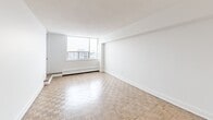 Located at 145-147 Wellington St W in Aurora, Ontario, this one-bedroom, one-bathroom unit offers a well-organized layout across a single floor. Warm parquet flooring runs throughout the main living areas, adding character and visual continuity to the space.

The living room is the largest area of the unit, bathed in natural light through a wide outward-facing window with a baseboard heater beneath it. Clean white walls and open sightlines give the room a bright, airy feel. A pass-through opening connects the living area to the kitchen, maintaining an open flow between the two spaces.

The kitchen is efficiently designed with white cabinetry, a subway tile backsplash, stainless steel countertops and appliances including a full-size refrigerator. Light tile flooring grounds the space and complements the crisp, minimal aesthetic.

The bedroom is a well-proportioned private retreat featuring parquet flooring, a large window with natural light and outward views, a baseboard heater, and mirrored sliding closet doors that enhance the sense of space.

The bathroom is finished with classic white subway tile surrounding the bathtub and shower combination, paired with a light stone-toned vanity countertop and tile flooring, creating a clean, timeless look.

A hallway connects the entry to the main living areas, completing this efficiently planned and neatly presented unit.