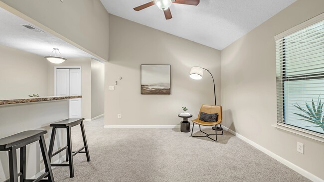 Immerse yourself in the comfort of our substantial living rooms adorned with plush carpeting and a refreshing ceiling fan. - The Fairpointe at Gulf Breeze