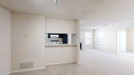 Located in Douglasville, GA, this single-floor, 2-bedroom, 1-bathroom home offers a well-organized and functional layout. The combined kitchen and living room area forms the heart of the home, where a pass-through kitchen counter with dark cabinetry, light countertops, a double sink, and white appliances — including a range, dishwasher, and refrigerator — opens toward the living space. The kitchen features wood-style flooring, while the adjoining living and dining areas are finished with plush neutral carpet throughout. The living room is bright with natural light and includes a fireplace, and a sliding glass door fitted with vertical blinds leads out to a private balcony with outdoor views. The primary bedroom is generously sized, featuring a ceiling fan with light, a window overlooking greenery, and a walk-in closet with built-in shelving. The second bedroom is carpeted with ample wall space. The bathroom is finished with wood-style flooring and includes a shower/tub combination. A dedicated laundry room with wood-style flooring, washer/dryer hookups, and overhead shelving adds everyday convenience. Textured ceilings are found throughout, contributing to the home's consistent, classic aesthetic.