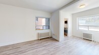 Located at 1650 Bathurst Street in Toronto's sought-after Forest Hill neighbourhood, this well-appointed 2-bedroom, 1-bathroom unit offers a thoughtfully laid-out single-floor plan with a clean, updated aesthetic. Light-toned laminate flooring runs consistently throughout, complementing the crisp white walls and white baseboards to create a bright, cohesive feel.

The spacious primary bedroom is generously sized, offering ample room for furnishings, and features a large window that draws in natural light along with a classic white cast-iron radiator. A closet and secondary door provide added convenience and connectivity to the rest of the unit. The second bedroom is similarly well-proportioned, also featuring a window with outdoor views and its own radiator, ensuring comfortable heating throughout the colder months.

The living area connects openly to the kitchen, which is equipped with stainless steel appliances and white cabinetry, offering a functional and modern cooking space. The bathroom is finished with white subway tile surrounding the bathtub, grey floor tiles, and a window for natural ventilation — presenting a clean, classic look. Classic radiator heating is present throughout the unit, reflecting the building's enduring character. The overall ambiance is fresh, neutral, and move-in ready.