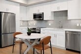 This 570 square foot apartment in Quincy, MA, offers a thoughtfully designed living space that maximizes functionality and style. The open-concept floor plan seamlessly integrates the kitchen, living, and dining areas, creating a spacious feel despite the compact footprint. The modern kitchen boasts sleek white cabinetry, stainless steel appliances, and a convenient island with bar seating, perfect for casual dining or entertaining.

The living room is bathed in natural light from large windows, complemented by warm wood flooring throughout. A mix of contemporary and mid-century modern furnishings adds character to the space. The bedroom, measuring 120 square feet, features a large window and ample closet space. The bathroom showcases a clean, minimalist design with a glass-enclosed shower.

Throughout the apartment, thoughtful details such as recessed lighting, stylish window treatments, and carefully curated artwork contribute to a cohesive and inviting atmosphere. The efficient layout ensures every square foot is utilized effectively, making this apartment an ideal urban retreat for those seeking a balance of comfort and modern living.