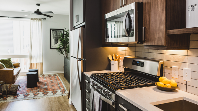 Chef-inspired galley kitchens with gas cooking, quartz counters and tile backsplash - Modera Reynoldstown