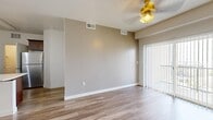 Located in Lehi, Utah, this well-designed one-bedroom, one-bathroom residence offers a practical and comfortable single-floor layout. The combined kitchen and living area serves as the heart of the home, featuring wood-look plank flooring that flows throughout. The living room is brightened by natural light streaming through a large sliding glass door fitted with vertical blinds, which opens to a private balcony with neighborhood views. A ceiling fan with light fixture adds to the room's functionality.

The kitchen is a standout feature, showcasing rich dark-stained cabinetry, light quartz countertops, and a peninsula with an undermount sink illuminated by pendant lighting. Black appliances, including a gas range and over-the-range microwave, complement the stainless steel refrigerator for a cohesive look.

The bedroom offers a comfortable retreat with plush carpeting, a bright window overlooking the surrounding neighborhood, and a dedicated closet. The full bathroom features matching dark wood vanity cabinetry, a light quartz countertop, a large mirror, and a tub-shower combination with wood-look tile flooring. A dedicated laundry room with overhead shelving and washer hookups adds everyday convenience to this thoughtfully arranged home.