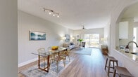 Located in Delray Beach, Florida, this well-appointed 2-bedroom, 2-bathroom residence offers a comfortable and functional single-floor layout filled with natural light. Wood-style flooring runs throughout, lending warmth and continuity to every room.

The open-concept living and dining area is generously sized, anchored by a ceiling fan and large sliding glass doors that invite natural light and provide access to a private balcony with outdoor views. The dining space accommodates a full-size table, while the living area offers ample room for relaxed entertaining.

The galley-style kitchen features granite countertops, white cabinetry, a mosaic tile backsplash, and stainless steel appliances, including a range, microwave, refrigerator, and dishwasher — a fully equipped space for everyday cooking.

The spacious primary bedroom includes two closets and a bright window with garden views, providing a peaceful retreat. The second bedroom is well-proportioned and equally well-lit. Both bathrooms are clean and functional, each featuring a tub-shower combination.

Additional highlights include a dedicated in-unit laundry room with a full-size washer and dryer, six closets distributed throughout for abundant storage, and hallways that connect the layout efficiently. The textured ceilings and neutral wall tones create a calm, cohesive aesthetic throughout the entire residence.