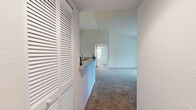 Located at 2785 Chaddsford Circle in Oviedo, FL, this single-story, 3-bedroom, 2-bathroom home offers a practical and comfortable layout. The combined kitchen and living area serves as the heart of the home, featuring soaring vaulted ceilings, track lighting, and a peninsula with a breakfast bar. The kitchen is equipped with white cabinetry, stone-look countertops, and black appliances. Wood-look flooring runs through the kitchen and living areas, while plush carpeting extends into the bedrooms and living room. A sliding glass door in the living room fills the space with natural light and provides outdoor access. The three bedrooms are well-sized, with the primary bedroom offering a walk-in closet with wire shelving. Bedrooms include ceiling fans and window blinds for comfort and privacy. The two bathrooms feature wood-look tile flooring, white vanities with stone-look countertops, and tub-shower combinations. A dedicated laundry room houses a full-size washer and dryer with additional wire shelving for storage. Two hallways connect the spaces efficiently, and two closets provide ample storage throughout the home.