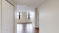 Located at 902 N Market St in the heart of Wilmington, DE, this two-bedroom, two-bathroom residence offers a well-designed single-floor layout with a clean, modern aesthetic throughout. Hardwood-style flooring runs continuously across the living areas and bedrooms, lending a cohesive and contemporary feel to the space.

The living room is bright and open, featuring large windows with bold black frames that frame sweeping views of the Wilmington cityscape, allowing abundant natural light to fill the room. The kitchen is efficiently laid out in a U-shaped configuration and is outfitted with stainless steel appliances — including a range, over-the-range microwave, refrigerator, and dishwasher — paired with granite countertops and cream-toned cabinetry.

Both bedrooms offer a calm, neutral palette with hardwood-style flooring and windows overlooking the city. The primary bedroom includes a closet, while the second bedroom provides a comfortable and functional space. Two hallways connect the rooms, contributing to a well-organized floor plan.

The bathrooms are tastefully finished: one features dark-framed cabinetry with a white countertop vanity and large-format tile flooring, while the other includes a full soaking tub and shower combination. Together, these details make for a practical and polished urban residence.