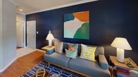 The Washington's two-bedroom, two-bathroom floor plan is thoughtfully designed across a single level, blending practical functionality with comfortable living spaces. The living room serves as a welcoming centerpiece, featuring warm wood-style flooring, crown molding, and a bold accent wall that adds a striking visual element to the space.

The kitchen is efficiently laid out with ample cabinetry, generous counter space, and a seamless connection to the dedicated dining area. The dining nook benefits from a large window with outdoor views, allowing natural light to filter through, and is finished with the same wood-style flooring that flows throughout the main living areas.

Both bedrooms are carpeted for comfort and equipped with ceiling fans. The primary bedroom features an accent wall, large windows with sheer drapery for natural light, and direct access to a closet. The second bedroom also includes a ceiling fan and a closet. Each bathroom is outfitted with a tub/shower combination, a single vanity with storage, and wood-style flooring, providing a clean and functional design. Overall, the space offers a cohesive and comfortable atmosphere throughout.