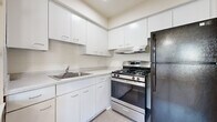Located at 2233 Hemmeter Rd in Saginaw, Michigan, this single-floor unit offers a clean, functional layout with a bright and open feel throughout. The spacious living area is carpeted and bathed in natural light from a large set of windows that frame outdoor views of surrounding greenery. A ceiling fan adds comfort, and baseboard heating runs along the perimeter walls. The open flow of the living space leads naturally toward the rest of the unit, with a warm wood-toned entry door adding a classic touch. The kitchen is well-appointed with crisp white cabinetry extending to the ceiling for ample storage, a tiled backsplash, light-toned countertops, a stainless steel gas range with an overhead vent hood, and a black refrigerator. Light vinyl flooring completes the kitchen's clean aesthetic. The bedrooms are carpeted and generously sized, each featuring windows with vertical blinds that allow for natural light and outdoor views, along with baseboard heating and wall-mounted air conditioning units. The bathroom includes classic mosaic tile flooring, a full tub-shower combination with white tile surround, built-in open shelving for storage, and a vanity with cabinet storage below. This unit offers a practical and comfortable living environment with functional features throughout.