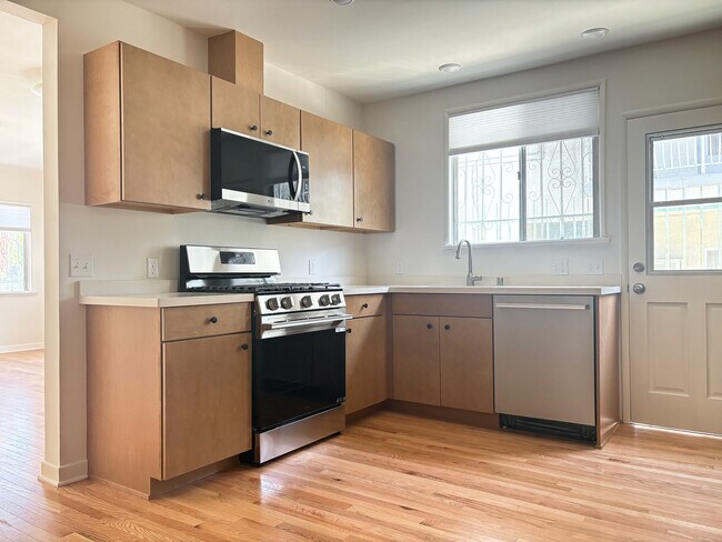 Cocina con electrodomésticos de acero inoxidable completamente nuevos, encimeras de cuarzo y gabinetes de arce. - 1041 Wilcox Ave