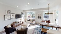 This thoughtfully designed single-floor residence offers a cohesive blend of modern aesthetics and functional living spaces. The gourmet kitchen serves as a central highlight, featuring light grey shaker cabinetry, striking white quartz countertops with veining detail, a herringbone tile backsplash, stainless steel appliances including a gas cooktop and double wall ovens, and a large island with a matte black sink. A brass cage pendant light anchors the island, adding a warm, contemporary touch. The open-concept living and dining area is bathed in natural light through expansive windows that frame views of the surrounding neighborhood. Recessed lighting and clean white walls create a bright, airy atmosphere, while the living area provides ample space for lounging and entertaining. The bedrooms are generously proportioned, each with plush carpeting, large windows that invite natural light, and well-considered layouts. One bedroom features a stylish four-poster canopy frame, while another offers a serene retreat with coordinated nightstands and curated wall art. The bathrooms maintain the home's clean aesthetic with white cabinetry, quartz surfaces, matte black fixtures, and framed mirrors. Throughout, the design is consistent, modern, and refined.