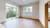 This well-appointed 2-bedroom, 2-bathroom residence on Old Sauk Road in Madison, Wisconsin offers a thoughtfully designed single-floor layout with a clean, modern aesthetic throughout. Light wood-tone flooring flows seamlessly across the living areas, bedrooms, and kitchen, creating a warm and cohesive atmosphere.

The kitchen serves as a central highlight, featuring light maple cabinetry, white subway tile backsplash, white quartz countertops, stainless steel appliances, and a spacious island with an integrated sink illuminated by striking black pendant lights. Open shelving adds both functionality and visual interest.

The living area is generously sized and filled with natural light from large windows and a sliding glass door that opens to a private balcony overlooking lush, mature trees — bringing a sense of the outdoors in.

The primary bedroom is comfortably sized, with a ceiling fan and a large window framing tranquil wooded views. The second bedroom is equally bright, featuring its own sizable window with outdoor greenery visible beyond. Each room includes dedicated closet space.

The two bathrooms are clean and functional — one featuring a full soaking tub and shower combo, and the other a walk-in shower with built-in shelving and grab bar. The overall design balances modern finishes with practical livability.