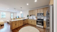 This thoughtfully designed 2-bedroom, 2-bathroom single-floor residence offers a functional and modern layout ideal for comfortable everyday living. The open-concept kitchen and living area serves as the heart of the home, featuring light natural wood cabinetry, quartz countertops, a white subway tile backsplash, and a full suite of stainless steel appliances including a refrigerator, electric range, microwave, and dishwasher. A peninsula with seating connects seamlessly to the dining and living spaces, all finished with warm hardwood-style flooring throughout.

The primary bedroom is a well-proportioned retreat with a sliding-door closet and a dedicated walk-in closet outfitted with wire shelving and hanging rods for ample storage. The second bedroom is bright and airy, benefiting from a window that invites natural light. Both bathrooms are finished consistently with light wood vanities, quartz countertops, large mirrors, and hardwood-style flooring, maintaining a clean and cohesive aesthetic.

A dedicated laundry room houses a full-size washer and dryer, adding everyday convenience. Neutral white walls, recessed lighting, and a consistent warm-toned palette throughout create a bright, welcoming ambiance that feels both modern and livable.