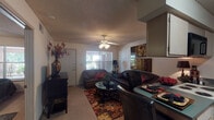 Located at 11500 S Memorial Dr in Bixby, Oklahoma, this single-floor residence offers a thoughtfully arranged layout with distinct living, dining, kitchen, bedroom, and bathroom areas. The living room serves as the heart of the home, featuring plush carpeting, a ceiling fan with integrated lighting, and a textured ceiling. Natural light filters through windows overlooking the surrounding greenery, creating a bright and inviting atmosphere. A breakfast bar with bar seating connects the living area to the kitchen, providing a convenient space for casual dining. The galley-style kitchen is efficiently designed with ample cabinetry, a full suite of appliances including an electric range, refrigerator, and dishwasher, and tile flooring for easy maintenance. The bedroom is a relaxed retreat, outfitted with carpeting, a ceiling fan, and a window that allows in natural light. The bathroom features tile flooring, a vanity with storage cabinetry, a mirror, and overhead lighting, maintaining a clean and functional aesthetic. Throughout the residence, a consistent warm color palette and practical finishes contribute to a cohesive and comfortable living environment suited for everyday life in the Bixby community.