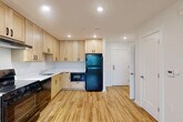 Located at 737 50th St NE in Washington, DC, this one-bedroom, one-bathroom unit offers a thoughtfully designed, efficient layout across a single floor. Light-toned hardwood flooring runs throughout the entire space, creating a warm and cohesive aesthetic.

The kitchen is a standout feature, equipped with abundant light maple cabinetry extending to the ceiling for generous storage, white countertops, and a full suite of black appliances including a gas range, refrigerator, built-in microwave, and dishwasher. Recessed lighting illuminates the kitchen and living areas, which flow seamlessly into an open-concept dining and living room. A wall-mounted mini-split unit provides climate control, and a large window invites natural light and outdoor views into the living area.

The bedroom offers a comfortable, private retreat with two double-door closets providing ample storage space and a window overlooking the neighborhood. A dedicated entrance and a separate laundry area with a stacked washer and dryer add practicality and convenience. The bathroom features classic white tile and a bathtub. Clean white walls and understated finishes throughout give the space a fresh, move-in-ready feel.