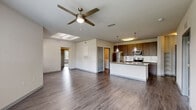 Located at 2509 Cattlemen Rd in Sarasota, FL, this single-floor, 3-bedroom, 2-bathroom residence offers a well-designed open-concept layout that seamlessly connects the living room, dining area, and kitchen. The living space features wood-style flooring, a ceiling fan with a skylight accent overhead, and large windows that invite abundant natural light. The kitchen is a functional centerpiece, equipped with stainless steel appliances including a refrigerator, range, and microwave, complemented by rich dark wood cabinetry, granite countertops, a subway tile backsplash, and a kitchen island with a built-in sink and pendant lighting. A dedicated pantry provides additional storage. The three bedrooms are carpeted and generously sized, with the primary bedroom offering access to a walk-in closet with wire shelving. Both bathrooms are finished with granite-topped vanities, dark wood cabinetry, and wood-style flooring; one features a glass-enclosed walk-in shower with white tile surround. An in-unit laundry room with washer and dryer hookups adds everyday convenience. The layout also includes a hallway connecting the private quarters and a patio for outdoor enjoyment.