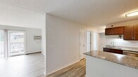 Located at 618 W Bridge St in Owatonna, Minnesota, this well-appointed 2-bedroom, 1-bathroom unit offers a practical and comfortable single-floor layout. The open-concept kitchen and living area serves as the heart of the home, featuring light luxury vinyl plank flooring throughout. The kitchen is equipped with rich dark-stained cabinetry, granite countertops, stainless steel appliances including an electric range and refrigerator, and a peninsula that provides additional prep space and separates the kitchen from the living area. The living room is bright and airy, highlighted by a sliding glass door that opens to a private balcony, allowing natural light to fill the space. Both bedrooms are carpeted for warmth and comfort, each featuring a ceiling fan, natural light from windows with blinds, and baseboard heating. The primary bedroom offers a comfortable, well-proportioned layout. The shared full bathroom continues the granite countertop theme with a large vanity mirror, an updated vanity, and a shower-tub combination. A dedicated closet provides additional storage. The unit's neutral color palette and consistent finishes create a clean, cohesive aesthetic throughout.