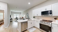 Located at 5790 Stockport St in Riverview, FL, this single-story, one-bedroom, one-bathroom home offers a well-designed layout with modern finishes throughout. Light wood-style flooring flows seamlessly across the entire space, contributing to a bright and cohesive aesthetic.

The open-concept kitchen and living area form the heart of the home. The kitchen is outfitted with crisp white shaker cabinetry, sleek white quartz countertops, stainless steel appliances including a gas range, built-in microwave, refrigerator, and dishwasher, and a peninsula with an undermount sink — ideal for casual dining or meal prep. The living area features elevated ceilings and multiple windows fitted with horizontal blinds, filling the room with natural light and creating an airy, welcoming atmosphere.

The bedroom offers a comfortable and serene retreat, complete with a ceiling fan, a natural light-filled window, and a closet. Neutral-toned walls complement the warm, understated design.

The bathroom is finished with a large walk-in shower enclosed by a sleek black-framed glass sliding door, paired with matching black fixtures that add a contemporary touch. The overall design of this home balances clean, modern elements with a warm and inviting ambiance.