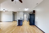 Located at 15707 Fowler Plaza in Omaha, Nebraska, this two-story home offers a well-organized layout across two levels. The entry level houses an attached garage with a clean concrete floor and automatic door opener, along with a carpeted staircase with a sleek metal handrail leading to the main living area above.

The expansive upper level encompasses a bright, open-concept living room, dining area, and kitchen. The kitchen is a standout feature, boasting granite countertops, a large center island with a double sink, dark cabinetry with modern hardware, and stainless steel appliances — all set atop light hardwood-style flooring that flows throughout the main living space. Ceiling fans with light fixtures are found in the living area and bedrooms.

The two bedrooms are finished with plush carpeting, ceiling fans, and ample natural light through horizontal-blind windows. Each bedroom includes access to a dedicated closet, with walk-in closets featuring built-in wire shelving systems for organized storage. The two bathrooms are finished with neutral tile flooring; one features a walk-in shower with chrome fixtures. A dedicated laundry area completes the upper level, adding everyday convenience to this thoughtfully designed home.