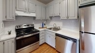 Located at 1711 Bellevue Ave in Richmond, Virginia, this single-floor residence offers a well-designed, functional layout with a clean, bright aesthetic throughout. The expansive main living area is a standout feature, showcasing warm hardwood flooring, crisp white walls, and dual windows that fill the space with generous natural light, creating an open and airy atmosphere.

The kitchen is thoughtfully appointed with gray cabinetry, white subway tile backsplash, light countertops, and a full suite of stainless steel appliances including a refrigerator, electric range, and dishwasher. A closeted storage area is conveniently positioned adjacent to the kitchen, adding to the home's practicality.

The bedrooms are carpeted for comfort and each features large windows with views of surrounding greenery, providing a calm and restful environment. Both bathrooms are finished consistently with white cabinetry, hardwood-style flooring, and tub-shower combinations with decorative curtains, offering a clean and functional design.

Throughout the residence, the textured ceilings, consistent white trim, and cohesive color palette contribute to a unified and well-maintained interior. The layout flows naturally from the living area through to the kitchen and private rooms, making efficient use of the available space.