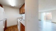 This single-floor unit is thoughtfully laid out, offering a functional and comfortable living environment. The living area serves as the central gathering space, featuring light wood-look flooring, a ceiling fan, and a sliding glass door that opens to a private balcony overlooking mature trees, filling the room with natural light. A pass-through window connects the living area to the kitchen, enhancing the open feel between spaces.

The galley-style kitchen is efficiently designed with warm medium-toned wood cabinetry lining both sides, white appliances including a coil-burner range and full-size refrigerator, light countertops, and durable wood-look flooring. A hallway leads from the main living area to the private quarters of the unit. The bedrooms are carpeted and offer a neutral palette, with windows fitted with vertical blinds allowing natural light, and baseboard heating units. Closets with hanging rods provide practical storage.

The bathroom features a clean, white tub and shower surround, a toilet, and a vanity with storage. Throughout the unit, textured ceilings, dark wood door trim, and sliding closet doors contribute to a consistent, utilitarian aesthetic.