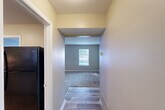 Located at 25 S Germantown Rd in Chattanooga, Tennessee, this single-floor, 2-bedroom, 2-bathroom residence offers a practical and comfortable layout. The living room is the largest area of the home, featuring plush carpeting and two windows that invite natural light and outdoor views, creating a bright and open atmosphere. A hallway connects the main living spaces, transitioning between wood-look plank flooring and carpeted areas throughout the home. The kitchen is equipped with white cabinetry, dark laminate countertops, a white electric range, and a black refrigerator, all set atop durable wood-look flooring with a dedicated space for a washer/dryer hookup. Both bedrooms are carpeted and finished in warm neutral tones, with windows providing natural light. The primary bedroom offers a generous footprint with ample wall space. Each bathroom includes a tub-shower combo, toilet, and vanity, with one bathroom featuring wood-look tile flooring and a window for natural ventilation. Three closets throughout the unit provide convenient storage. The overall color palette of soft beiges and grays gives the space a clean, move-in ready appearance well-suited for comfortable everyday living.