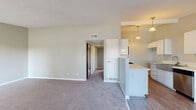 Located at 4905 Castana Ave in Lakewood, CA, this single-story 2-bedroom, 1-bathroom home offers a well-designed layout with a practical and comfortable flow throughout. The living room greets you at the entry with a classic front door featuring a sunburst transom window, soft carpeting, and a large window that fills the space with natural light and views of the surrounding greenery. The kitchen is a standout feature, designed in a galley style with white cabinetry, light stone countertops, stainless steel appliances including a gas range, microwave, and dishwasher, wood-look flooring, and stylish pendant lighting overhead. A peninsula counter connects the kitchen to the living area, enhancing the open feel. Both bedrooms are carpeted and finished in neutral tones. The primary bedroom is generously sized and includes a mirrored sliding closet and a ceiling fan, while the secondary bedroom offers a reach-in closet and a window with pleasant outdoor views. The full bathroom is clean and functional, featuring a tub/shower combo, a single-sink vanity with stone countertop, and wood-look flooring. Two hallways connect the rooms efficiently, rounding out a cohesive and move-in ready floor plan.