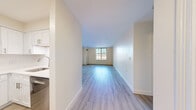 This thoughtfully laid-out residence features three bedrooms, two bathrooms, and a single-floor plan designed to maximize functionality and comfort. The open living and dining area is finished with light-toned hardwood-style flooring and neutral walls, creating a bright and welcoming atmosphere. A window at the far end of the living space allows natural light to fill the room.

The kitchen is well-appointed with crisp white shaker-style cabinetry, stainless steel appliances including a refrigerator, gas range with over-the-range microwave, and dishwasher. Light hardwood flooring completes the clean, modern aesthetic.

The primary bedroom is generously sized, featuring hardwood-style flooring and a large window with views of the surrounding neighborhood. The two additional bedrooms are carpeted and each equipped with their own windows that provide natural light and outdoor views, along with closet storage.

Both bathrooms are finished with neutral stone-look tile flooring and marble-tiled tub-shower surrounds. One bathroom includes a white vanity with a mirrored medicine cabinet and brushed gold hardware accents, adding a refined touch.

Throughout the residence, the consistent use of neutral tones, clean lines, and modern finishes creates a cohesive, move-in ready environment that balances practicality with understated style.