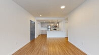 Located at 16525 Ash Way in Lynnwood, Washington, this thoughtfully designed 2-bedroom, 2-bathroom residence offers a clean, modern aesthetic throughout its single-floor layout. Light wood-tone laminate flooring flows seamlessly through every room, complementing the crisp white walls and creating a bright, cohesive atmosphere.

The open-concept kitchen and living area forms the heart of the home. The kitchen is well-appointed with light wood cabinetry extending to the ceiling for ample storage, stainless steel appliances including a refrigerator, range, and microwave, white quartz countertops, and a peninsula with an integrated sink. Recessed lighting illuminates the space efficiently. The adjacent living room is generously sized, featuring a wall-mounted mini-split system and a large window that invites natural light and outdoor views.

The primary bedroom is a spacious retreat with a wide picture window overlooking the neighborhood and access to a walk-in closet outfitted with wire shelving. Its en-suite bathroom features a frameless sliding glass shower enclosure, light wood vanity, and white quartz countertop. The second bedroom also benefits from a large window and is served by a second full bathroom with a matching vanity and large mirror. A hallway connects all rooms, completing this well-organized, move-in-ready residence.