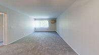 Located at 195 W Kennett Rd in Pontiac, Michigan, this single-floor, two-bedroom, one-bathroom unit offers a practical and comfortable layout. The open-concept living and kitchen area features a combination of wood-style hard flooring and plush carpet, with warm-toned cabinetry, a refrigerator, and a convenient pass-through kitchen setup that connects to the main living space. A ceiling fan adds comfort to this area, while vertical blinds on large windows allow for adjustable natural light. A wall-mounted HVAC unit and baseboard heating provide year-round climate control throughout the home. The generously sized primary bedroom is carpeted and includes a large double closet, offering ample storage. The second bedroom is also carpeted and features a window with vertical blinds and baseboard heating, creating a bright and cozy space. Both bedrooms maintain a clean, neutral palette. The bathroom is fitted with a full tub-shower combo lined with classic white square tile, lending a clean and timeless look. A connecting hallway ties the rooms together efficiently. Overall, the unit presents a functional, move-in-ready layout suited for everyday living.