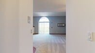 This 940 square foot townhouse in Madison, WI offers a blend of comfort and functionality across two floors. The ground level, spanning 600 square feet, features an open concept living and kitchen area. The living room boasts vaulted ceilings, a cozy fireplace, and large arched windows that flood the space with natural light. The adjacent kitchen is equipped with white cabinetry, contrasting wood trim, and essential appliances.

A wooden staircase leads to the 340 square foot upper level, which includes a loft-style area illuminated by a skylight. This versatile space could serve as a bedroom or home office. The bathroom, finished with wood accents and neutral tones, provides a clean and functional design. Two closets offer ample storage throughout the home.

The property's neutral color palette, featuring gray carpeting and white walls with wood trim, creates a bright and adaptable living environment. The combination of open spaces and defined areas allows for flexible use of the townhouse, making it suitable for various lifestyle needs.