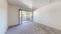 Located at 7826 Center Pkwy in Sacramento, CA, this single-story, one-bedroom, one-bathroom unit offers a practical and well-organized floor plan across a compact but functional footprint. The combined kitchen and living area forms the heart of the unit, where wood-look flooring, a ceiling fan, and an open layout create a cohesive and comfortable space. The kitchen is equipped with gray cabinetry — both upper and lower — providing generous storage, along with light countertops, a stainless steel sink, and black appliances including a refrigerator and range. A peninsula counter separates the kitchen from the living area, adding a sense of definition to the space. The living room features plush carpeting and sliding glass doors that open to a private balcony, bringing in natural light and views of surrounding greenery. The bedroom is a well-proportioned, carpeted retreat with a large window that admits natural light, and a sliding-door closet that offers ample storage. The bathroom features wood-look flooring, a vanity with stone-look countertop and gray cabinetry, and a separate room housing the toilet and a full bathtub with a clean, white surround. Clean white walls and neutral finishes throughout contribute to a bright, move-in ready aesthetic.