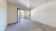 Located at 7826 Center Pkwy in Sacramento, CA, this single-story, one-bedroom, one-bathroom unit offers a practical and well-organized floor plan across a compact but functional footprint. The combined kitchen and living area forms the heart of the unit, where wood-look flooring, a ceiling fan, and an open layout create a cohesive and comfortable space. The kitchen is equipped with gray cabinetry — both upper and lower — providing generous storage, along with light countertops, a stainless steel sink, and black appliances including a refrigerator and range. A peninsula counter separates the kitchen from the living area, adding a sense of definition to the space. The living room features plush carpeting and sliding glass doors that open to a private balcony, bringing in natural light and views of surrounding greenery. The bedroom is a well-proportioned, carpeted retreat with a large window that admits natural light, and a sliding-door closet that offers ample storage. The bathroom features wood-look flooring, a vanity with stone-look countertop and gray cabinetry, and a separate room housing the toilet and a full bathtub with a clean, white surround. Clean white walls and neutral finishes throughout contribute to a bright, move-in ready aesthetic.