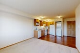 This one-bedroom, one-bathroom unit at 9615 Holly Dr in Everett, Washington offers a practical and well-organized layout across a single floor. The open living area features neutral carpet and connects seamlessly to the kitchen, which is outfitted with warm oak cabinetry, a full suite of white appliances including a dishwasher, electric range, refrigerator, and microwave, along with a double sink and ample counter space. A convenient in-unit stacked washer and dryer is tucked just off the kitchen area. The hardwood-style flooring in the kitchen adds a clean contrast to the carpeted living and bedroom spaces. The bedroom is a well-proportioned room featuring plush carpet, a baseboard heater, and a window that frames views of mature evergreen trees, filling the space with natural light. A dedicated closet provides additional storage. The bathroom includes a full tub and shower combination with a grab bar, a wood-toned vanity, and hardwood-style flooring. Throughout the unit, warm wood trim accents white walls, creating a clean and cohesive aesthetic. Located in Everett, WA, this unit combines functional design with comfortable livability.