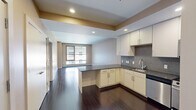 Located at 20 Front St in downtown Hartford, CT, this well-appointed one-bedroom, one-bathroom residence offers a thoughtfully designed single-floor layout. Rich dark hardwood flooring runs throughout the main living areas, creating a warm and polished aesthetic.

The open-concept kitchen and living room form the heart of the unit. The kitchen is outfitted with stainless steel appliances — including a gas range, microwave, dishwasher, and refrigerator — complemented by white cabinetry, dark granite countertops, and a mosaic tile backsplash. A peninsula provides additional counter space and naturally delineates the kitchen from the living area, which benefits from large windows that invite natural light and urban views.

The entryway features dark hardwood floors and access to multiple closets, offering ample storage. The generously sized bedroom is finished with plush carpet and a large window that brightens the space. The bathroom is appointed with large-format tile flooring, a dark wood vanity with under-sink storage, and a framed mirror. In-unit laundry adds everyday convenience. Three closets throughout the unit ensure practical storage solutions. The overall ambiance is modern and clean, suited for urban living in the heart of Hartford.
