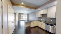 Located at 20 Front St in downtown Hartford, CT, this well-appointed one-bedroom, one-bathroom residence offers a thoughtfully designed single-floor layout. Rich dark hardwood flooring runs throughout the main living areas, creating a warm and polished aesthetic.

The open-concept kitchen and living room form the heart of the unit. The kitchen is outfitted with stainless steel appliances — including a gas range, microwave, dishwasher, and refrigerator — complemented by white cabinetry, dark granite countertops, and a mosaic tile backsplash. A peninsula provides additional counter space and naturally delineates the kitchen from the living area, which benefits from large windows that invite natural light and urban views.

The entryway features dark hardwood floors and access to multiple closets, offering ample storage. The generously sized bedroom is finished with plush carpet and a large window that brightens the space. The bathroom is appointed with large-format tile flooring, a dark wood vanity with under-sink storage, and a framed mirror. In-unit laundry adds everyday convenience. Three closets throughout the unit ensure practical storage solutions. The overall ambiance is modern and clean, suited for urban living in the heart of Hartford.