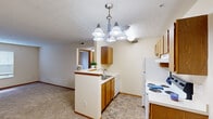 Located at 5160 Preferred Pl in Hilliard, Ohio, this single-floor, one-bedroom, one-bathroom unit offers a practical and well-organized layout. The kitchen is equipped with warm oak cabinetry, a white electric range, a full-size refrigerator, and a peninsula with a built-in sink that provides additional counter space and a natural division from the adjacent dining area. The dining space is illuminated by a multi-light chandelier and features tile flooring that extends throughout the kitchen, creating a cohesive and easy-to-maintain common area. A hallway connects the main living spaces to the private bedroom, which is generously proportioned and finished with soft carpeting. A large window in the bedroom allows ample natural light to fill the room throughout the day. A dedicated closet provides convenient storage, and the hallway leads to the full bathroom, which includes a single-sink vanity with oak cabinetry, a wall-mounted mirror, tile flooring, and a shower-tub combination. Neutral wall tones and warm wood trim carry throughout the unit, lending a consistent and clean aesthetic. The overall layout is thoughtfully designed to maximize functionality within a compact and cozy footprint, making it a practical option in the Hilliard community.
