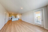 Located at 91 Market St in Winder, Georgia, this well-appointed one-bedroom, one-bathroom unit offers a thoughtfully designed single-floor layout. The open-concept kitchen and living area serves as the heart of the home, featuring light hardwood-style flooring, recessed lighting, and large windows that invite abundant natural light. The kitchen is equipped with stainless steel appliances, including a refrigerator, range, and microwave, complemented by granite countertops, a subway tile backsplash, gray cabinetry, and a central island with a sink—ideal for both cooking and casual dining.

The living area extends to an exterior door with glass panels, providing outdoor access and additional natural light. The bedroom is carpeted for comfort, includes a ceiling fan, and benefits from multiple windows offering outdoor views. It connects directly to the full bathroom, which features a double-sink vanity with granite countertops, gray cabinetry, and a tiled soaking tub. A dedicated laundry room houses a full-size washer and dryer with overhead wire shelving for added storage. The unit presents a clean, contemporary aesthetic throughout.