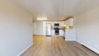 Located at 12155 W 58th Pl in Arvada, Colorado, this single-floor unit offers a practical and well-maintained layout designed for comfortable everyday living. The open-concept living and kitchen area is anchored by light wood-style vinyl flooring that runs throughout the main spaces, creating a clean and cohesive look. The kitchen is a standout feature, outfitted with white shaker-style cabinetry, dark countertops, and a full suite of stainless steel appliances including a refrigerator, electric range, microwave, and dishwasher. A baseboard heating unit in the living area ensures warmth, and a sliding glass door opens to a private balcony, bringing in natural light and outdoor views. The bedrooms are carpeted for comfort and finished with neutral gray walls. One bedroom features dual sliding closets, providing generous storage. Both bathrooms are clean and functional — one includes a tub-shower combination with white subway tile surround and wood-style flooring, while the second offers a vanity with a medicine cabinet mirror and a tiled shower-tub combo. The textured ceilings and understated finishes throughout give the unit a straightforward, move-in-ready character well suited to the Arvada community.