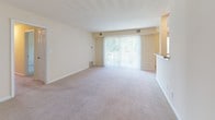 Located at 3009 Crossfork Dr in Wilmington, Delaware, this single-floor residence offers a practical and comfortable layout designed for everyday living. The spacious living area is finished with neutral-toned wall-to-wall carpeting and is bathed in natural light through large sliding glass doors that open to an outdoor view, creating a bright and welcoming atmosphere. A pass-through counter connects the living area to the kitchen, which features light wood cabinetry, stainless steel appliances including a refrigerator, range, and microwave, and durable tile flooring. The layout also includes a dedicated dining or additional living space adjacent to the kitchen. Multiple bedrooms offer generous proportions, each with soft carpeting, cream-toned walls, and windows fitted with blinds that frame views of the surrounding greenery, allowing ample natural light throughout. The bathrooms are finished with neutral ceramic tile flooring and include full-size bathtubs with shower fixtures, along with chrome hardware accents. The overall design emphasizes a clean, functional aesthetic with consistent warm neutral tones throughout, making it a versatile and move-in ready space in the Wilmington, DE area.