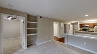 Located at 8720 Knickerbocker Way in Indianapolis, IN, this one-bedroom, one-bathroom residence offers a thoughtfully designed single-floor layout that maximizes functionality and comfort. The open-concept living and dining area features warm hardwood-style flooring, neutral toned walls, and built-in shelving that adds both character and practical storage. A sliding glass door at the end of the living area invites natural light and provides access to an outdoor balcony area.

The kitchen is a standout feature, equipped with rich dark cabinetry, granite countertops, stainless steel appliances including a refrigerator, microwave, and range, as well as a dishwasher. A peninsula with a granite overhang and built-in sink connects the kitchen to the main living space, making it ideal for both cooking and entertaining.

The bedroom is a comfortable retreat with plush carpet flooring, a ceiling fan, and a window overlooking a lush outdoor setting. A closet with panel doors provides ample storage. The bathroom offers hardwood-style flooring, a dark wood vanity with a white countertop, and clean, neutral finishes throughout. The overall ambiance is warm, modern, and move-in ready.