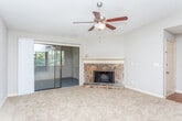 This single-floor residence at 2125 Defoors Ferry Rd NW in Atlanta, Georgia, offers a well-designed layout that balances comfort and functionality throughout. The living room serves as a central gathering space, anchored by a striking stone fireplace with a classic white mantel and complemented by plush carpeting and a ceiling fan overhead. Sliding glass doors lead to an enclosed patio, allowing natural light to fill the room. Adjacent to the living area, a dedicated dining space features its own pendant light fixture, creating a natural separation between the two zones. The kitchen is outfitted with white cabinetry, granite-style countertops, warm hardwood-style flooring, and black appliances including a gas range, microwave, and refrigerator. The bedrooms are generously sized, each with soft carpeting, ceiling fans, and windows that bring in views of surrounding greenery. Two bathrooms serve the residence; both feature white vanity cabinetry with granite-style countertops and large mirrors. The primary bathroom includes a double-sink vanity and a separate tub and shower area with classic white tile. Hardwood-style flooring extends through the bathrooms, adding a cohesive warmth to the overall design.