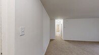 Located at 600 Old Street Road in Feasterville, PA, this two-bedroom, one-bathroom unit offers a straightforward and functional single-floor layout. The open living area features neutral wall-to-wall carpeting, crisp white walls, and a ceiling fan with light fixture, creating a bright and airy atmosphere. The space is thoughtfully arranged, with a partial wall division adding definition to the living area without sacrificing openness.

The generously sized primary bedroom is carpeted and benefits from natural light streaming through a window fitted with horizontal blinds. A second bedroom, also carpeted, includes a closet with bifold doors and provides a comfortable, quiet retreat.

The kitchen is equipped with a gas range, wooden cabinetry, speckled countertops, and tile flooring. A window above the counter looks out to a green outdoor view, allowing natural light to brighten the workspace. A ventilation fan is also present above the cooking area.

The bathroom features full-surround ceramic tile walls in a warm beige tone, complementing the white soaking tub and sink. The tile work is neatly laid in a brick pattern, giving the bathroom a clean and polished appearance. Overall, this unit offers a well-maintained, move-in-ready space with a neutral palette suitable for a variety of décor styles.