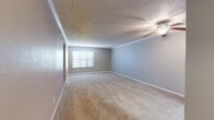 This single-floor residence offers a thoughtfully laid-out interior with a neutral color palette and functional design throughout. The generously sized living area is finished with plush wall-to-wall carpeting, crown molding, a textured ceiling, and a ceiling fan with integrated lighting. A large window with horizontal blinds invites natural light into the space, creating a bright and welcoming atmosphere.

The kitchen is well-appointed with gray cabinetry, white countertops, a tile mosaic backsplash, and warm wood-look flooring. Stainless steel appliances — including a refrigerator, electric range, and dishwasher — provide a modern, cohesive look. A window above the sink adds additional natural light to the cooking space.

The bedrooms are carpeted and finished with crown molding and ceiling fans. One bedroom features mirrored sliding closet doors, while another offers a bright window with ample natural light. Both bathrooms are equipped with tub-shower combinations and tile surrounds; one features over-toilet cabinetry for added storage, while the other includes a vanity with under-sink storage and warm hardwood-style flooring. The overall design is clean, neutral, and move-in ready.