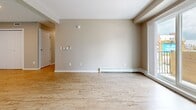 Located at 1070 Noëlla Leclair Way in Ottawa, Ontario, this well-appointed 3-bedroom, 2-bathroom unit offers a clean, modern aesthetic across a single-level floor plan. Light wood laminate flooring runs consistently throughout the space, lending warmth and visual continuity to every room.

The kitchen is outfitted with crisp white cabinetry, dark granite countertops, and black appliances including a refrigerator, electric range, and dishwasher. Recessed lighting and a neutral colour palette keep the space feeling bright and functional. The kitchen opens toward the living area, creating a connected and practical flow.

The living room is generously proportioned, featuring baseboard heating, a wall-mounted mini-split system for climate control, and large windows that bring in ample natural light with views of the surrounding neighbourhood.

The three bedrooms are well-sized, each featuring light wood flooring, baseboard heaters, and windows overlooking the exterior. The primary bedroom includes a built-in closet with bifold doors, offering practical storage. The two bathrooms are finished with white cabinetry, dark countertops, and wood-look flooring — one featuring a full soaker tub and shower combo, and the other a standalone vanity and toilet.