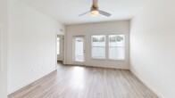 Located at 9000 Little Palm Way in Venice, FL, this thoughtfully designed single-story home offers a bright, modern interior with a clean, neutral palette throughout. The open-concept living and dining area is filled with natural light from multiple windows fitted with sleek blinds, and is complemented by light wood-look flooring and a ceiling fan. The well-appointed kitchen is a standout feature, showcasing white shaker cabinetry, quartz countertops, a gray subway tile backsplash, a stainless steel undermount sink, and a full suite of stainless steel appliances including a refrigerator with ice maker, electric range, built-in microwave, and dishwasher. A large island provides additional prep and dining space. The spacious bedroom benefits from abundant natural light through large windows, warm wood-look flooring, a ceiling fan, and access to a dedicated walk-in closet. The full bathroom features a white vanity with quartz countertop, a large mirror, and a glass-enclosed tiled shower. A separate laundry room houses a full-size washer and dryer. Outside, the property includes a generously sized, fully fenced backyard with vibrant artificial turf, offering a private and low-maintenance outdoor retreat.