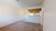 Located at 5651 E Edison St in Tucson, Arizona, this single-floor unit offers a straightforward and functional layout designed for comfortable everyday living. The open living area is finished with wall-to-wall carpeting and a textured ceiling, and it flows naturally toward the kitchen through a convenient pass-through breakfast bar. A ceiling fan provides additional air circulation over the living space. Natural light enters through windows fitted with vertical blinds, and a wall-mounted HVAC unit ensures climate control throughout the year.

The kitchen is efficiently arranged with warm-toned wood cabinetry lining both upper and lower sections, light-colored countertops, and durable wood-look vinyl flooring. White appliances — including a coil-top electric range with overhead ventilation, a full-size refrigerator, and a sink — provide all essential cooking and food storage needs.

The bedroom is a well-proportioned, carpeted space with its own wall-unit air conditioner and a window with vertical blinds for privacy and natural light. The bathroom features wood-look vinyl flooring, a single-sink vanity with warm wood cabinetry, a full-size soaking tub and shower combination with wood-patterned surround panels, and a mirrored vanity above the sink. The overall aesthetic throughout the unit is clean, neutral, and practical.