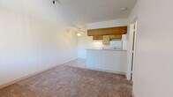 Located at 5651 E Edison St in Tucson, Arizona, this single-floor unit offers a straightforward and functional layout designed for comfortable everyday living. The open living area is finished with wall-to-wall carpeting and a textured ceiling, and it flows naturally toward the kitchen through a convenient pass-through breakfast bar. A ceiling fan provides additional air circulation over the living space. Natural light enters through windows fitted with vertical blinds, and a wall-mounted HVAC unit ensures climate control throughout the year.

The kitchen is efficiently arranged with warm-toned wood cabinetry lining both upper and lower sections, light-colored countertops, and durable wood-look vinyl flooring. White appliances — including a coil-top electric range with overhead ventilation, a full-size refrigerator, and a sink — provide all essential cooking and food storage needs.

The bedroom is a well-proportioned, carpeted space with its own wall-unit air conditioner and a window with vertical blinds for privacy and natural light. The bathroom features wood-look vinyl flooring, a single-sink vanity with warm wood cabinetry, a full-size soaking tub and shower combination with wood-patterned surround panels, and a mirrored vanity above the sink. The overall aesthetic throughout the unit is clean, neutral, and practical.